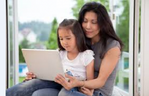 parent with child on lap and computer
